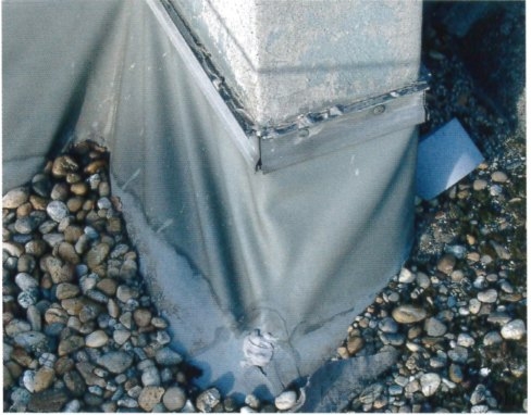 PVC-lemezes szigetelés elhúzódása és átszakadása az attikafalból kinyúló pillércsonk körül.