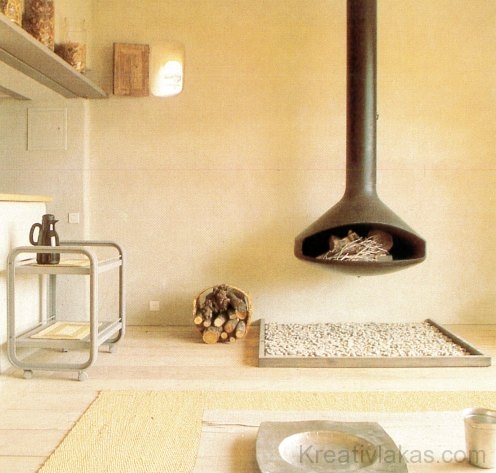 Rusztikus egyszerűség egy francia parasztházban; a modern kandalló belesimul a hagyományos környezetbe.